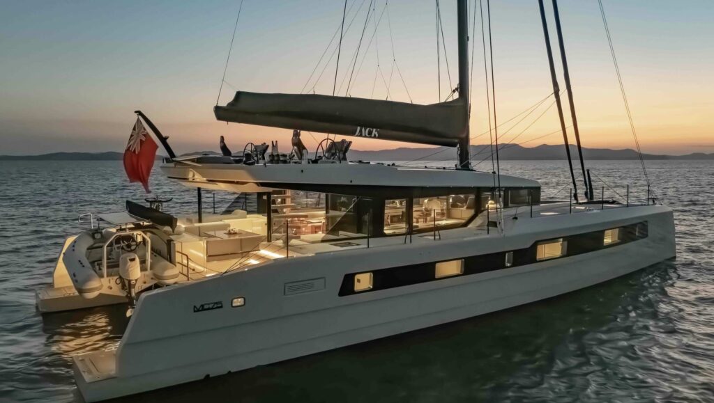Foto lateral de um catamarã de luxo ao anoitecer