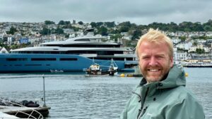 Adam Greene in front of a superyacht