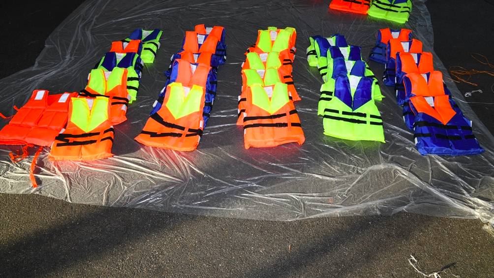 Multi-coloured lifejackets laid out in lines after being seized by NCA