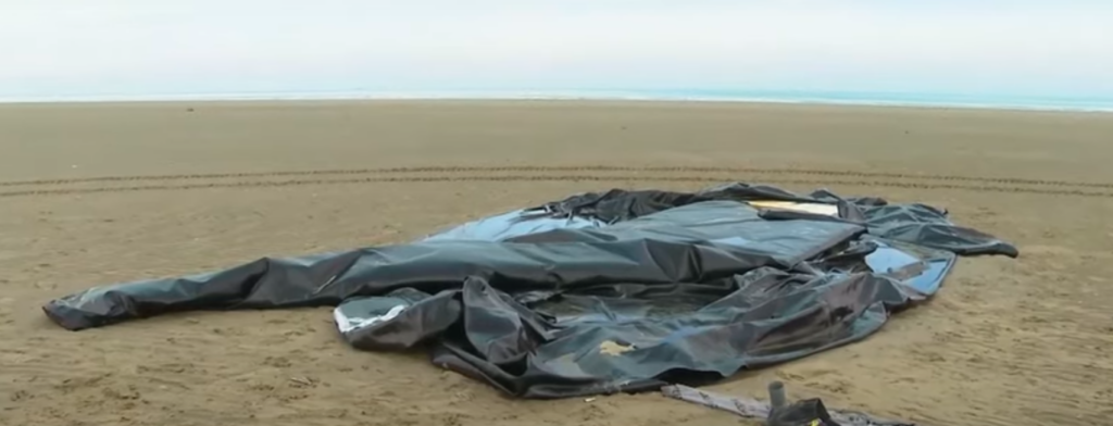 Dinghy abandoned on sandy beach - of the type used by people smugglers