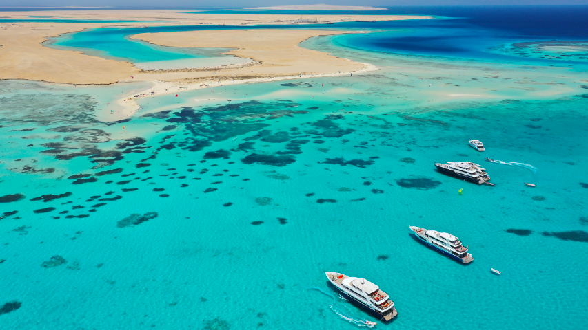 aerial view boats in crystal clear water with sand back. this is Saudi Arabia Red Sea