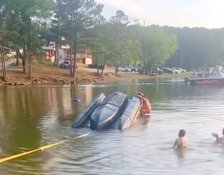 Person in water and line on upside down Sea-Doo Switch after it flipped in water