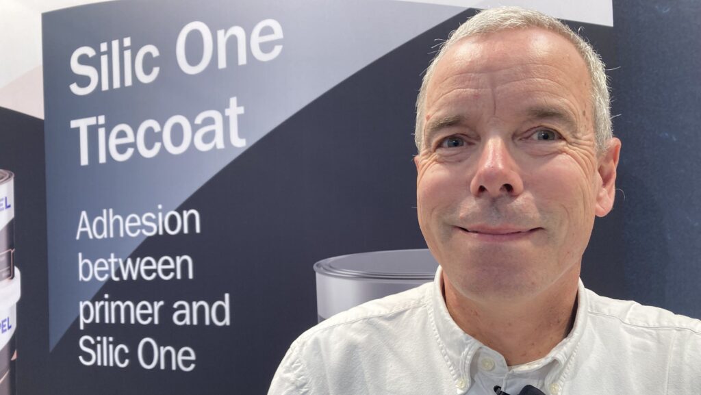 Thomas Olsen pictured in front of stand advertising Hempel's Silic One as he launched Infinity - a recharger for silicon systems