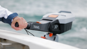 a hand on a Torqeedo electric outboard with water behind