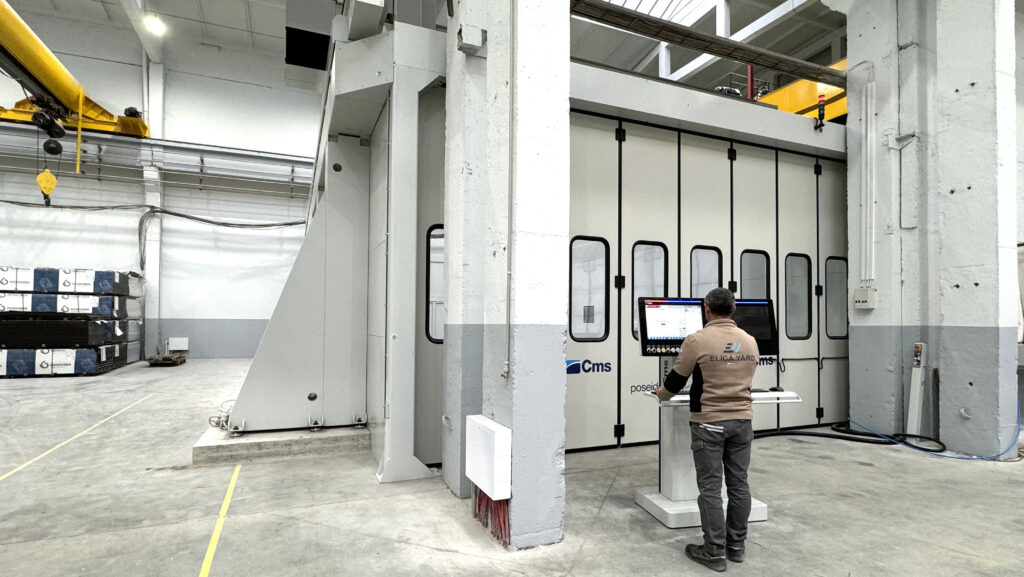 factory interior with man standing by small screen