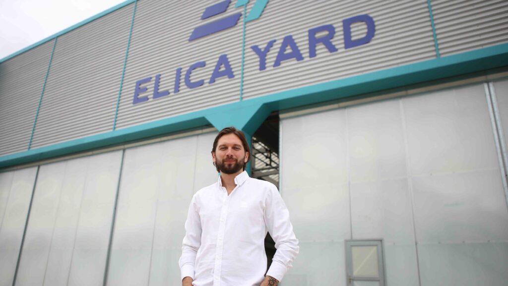 man standing in front of Elica Yard factory hanger