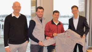 four business men showing off a sailing jacket