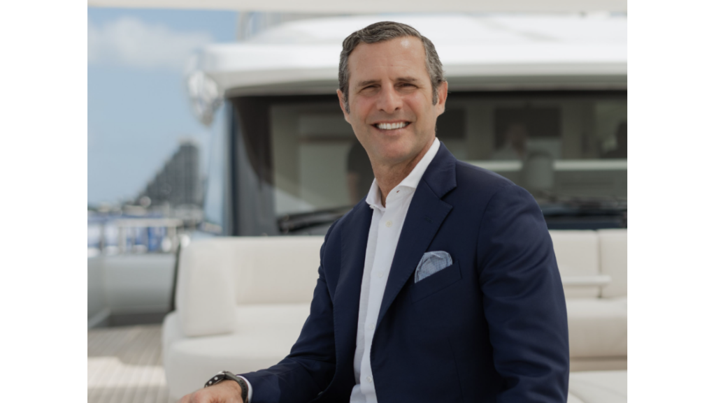 man in suit sitting on foredeck of yacht