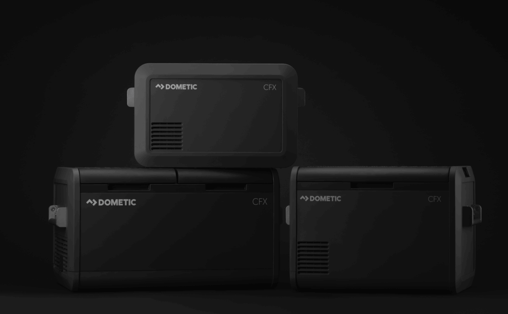 Fotografía oscura del producto de tres refrigeradores eléctricos negros y un paquete de baterías de Dometic