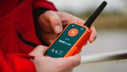 Orange man overboard handheld distress beacon in hands