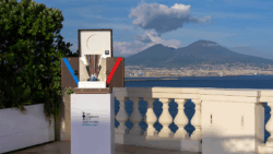trophy on box in front of Naples iconic backdrop as America's Cup host city announced