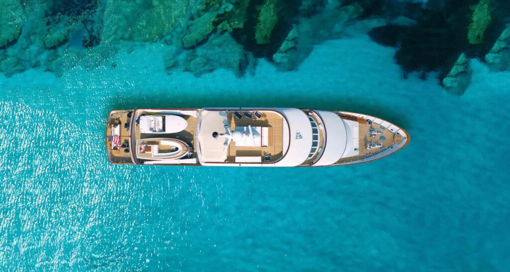 Aerial image of a superyacht on bright blue water to illustrate the environmental credentials of HVO fuel for superyachts (ref BFuture)