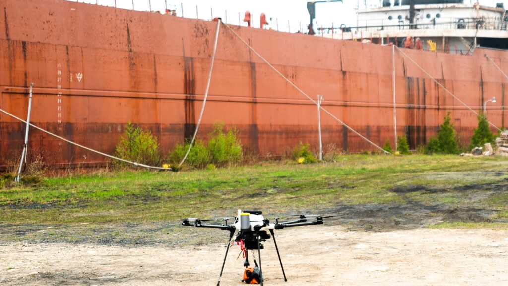 Drone on concrete in front of berthed containership as tests for shore-to-ship drone delivery take place