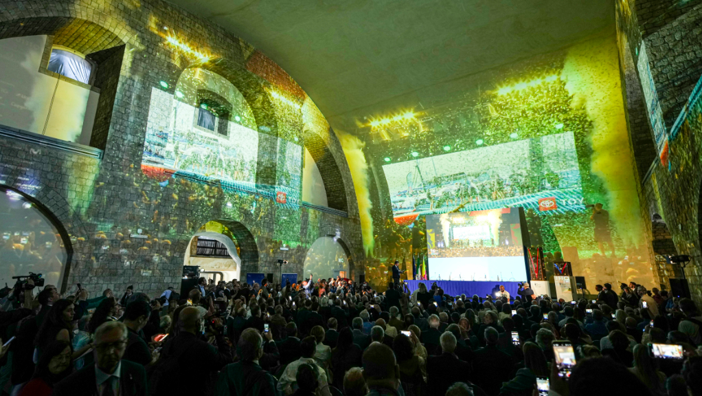 Images projected inside a castle as crowds watch Naples being declared for 2027 America's Cup