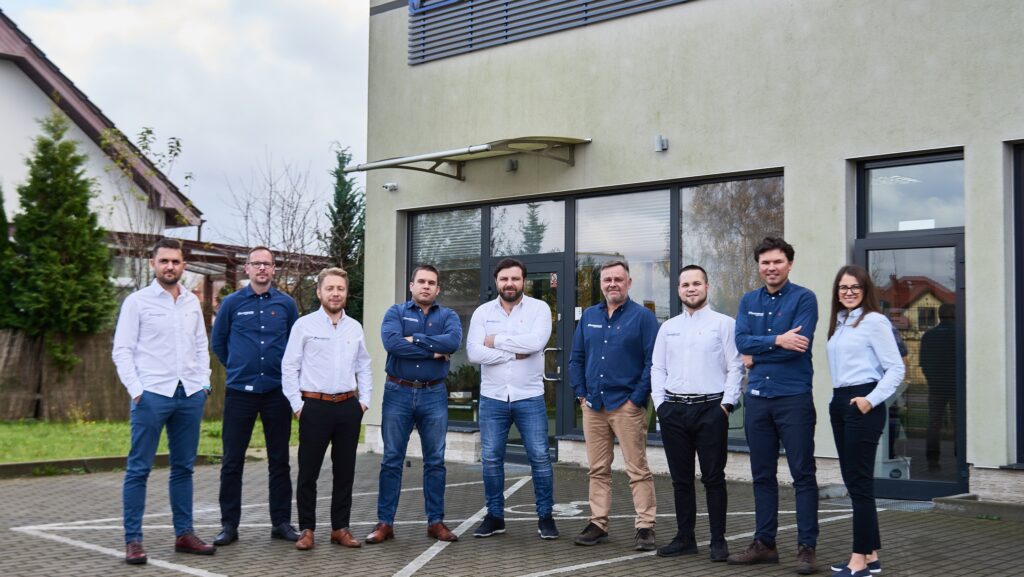 Eine Gruppe von Menschen steht vor einem Büro in Polen. Das ist das Team von Marineworks
