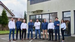 A group of people stand in front of an office in Poland. This is Marineworks' team