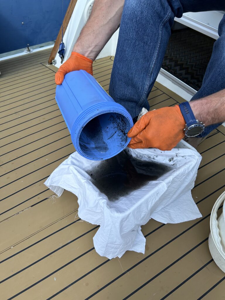 Filter system for yacht with debris being tipped onto collection point to show how much pollution - including microplastics - can be stopped from entering MPA. Wave International product