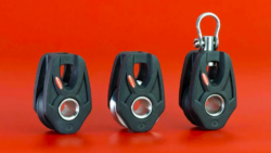Three orbit blocks in a line on a red background. These are Ronstan's 25 ball bearing orbit blocks