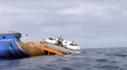 A small submersible is tipped into sea off back of boat. It's the ill-fated Titan which later imploded while viewing wreck of Titanic
