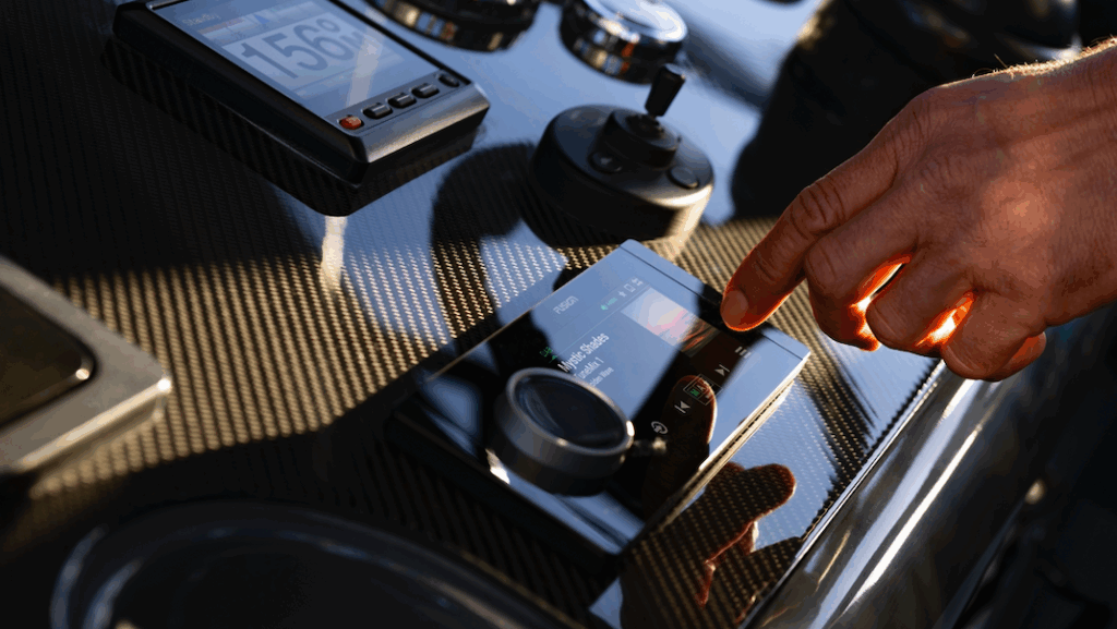 man's hand touches control on Garmin's Fusion Apollo RA800 marine stereo