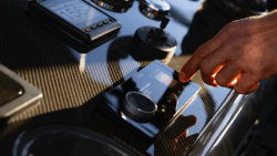 man's hand touches control on Garmin's Fusion Apollo RA800 marine stereo
