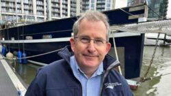 headshot of man by bow of large yacht