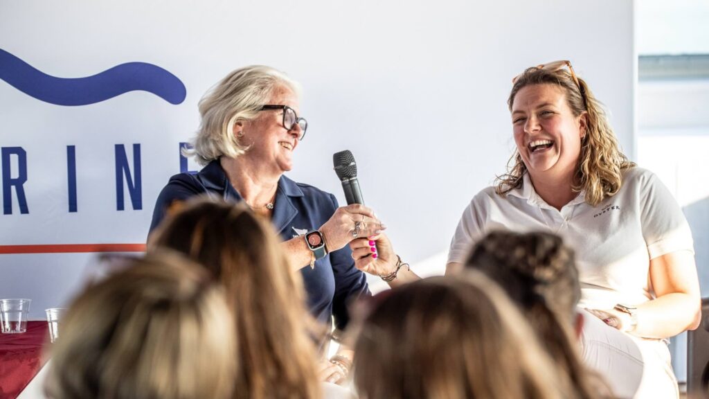 Two women laughing on stage panel discussion
