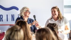 Two women laughing on stage panel discussion