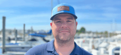 Headshot of man in cap by marina