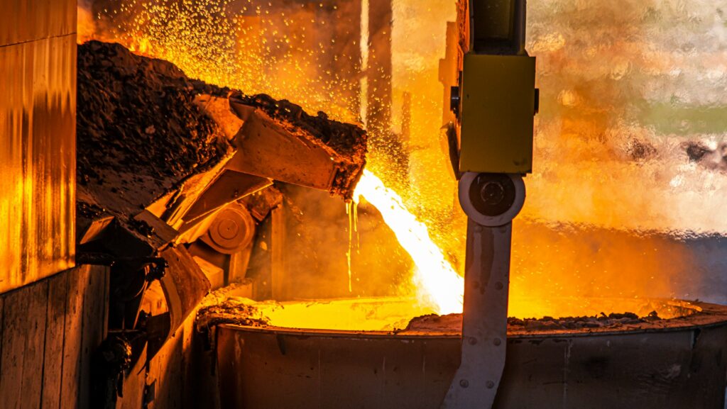 Glowing steel factory amid steel tariff increase debate.