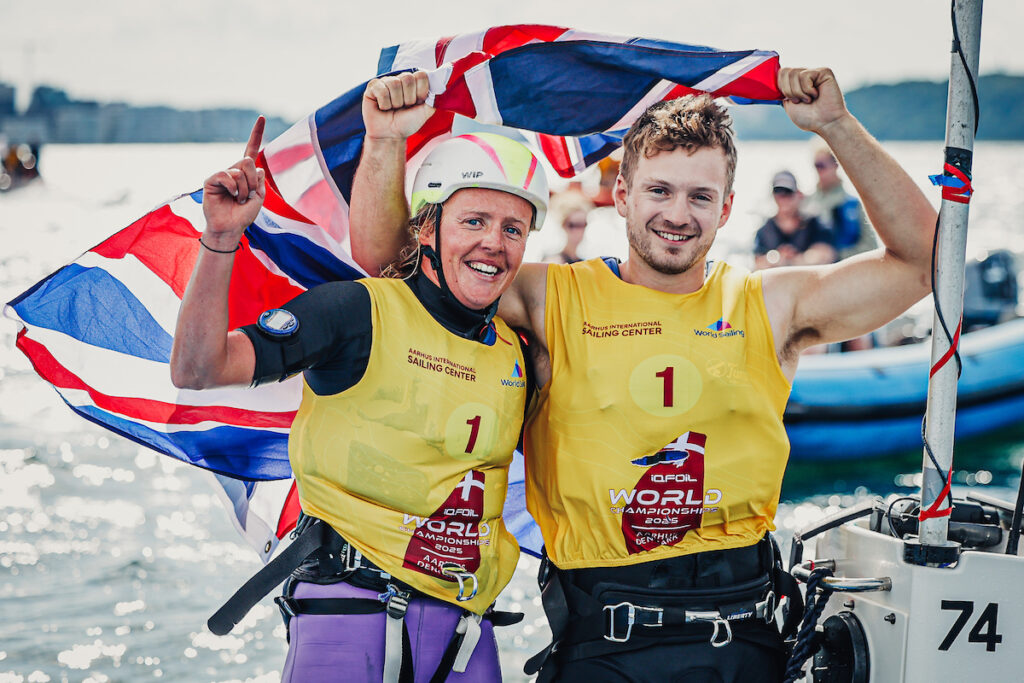 a man and woman celebrating a foiling boat win