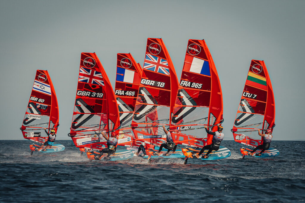 a group of red foiling boats racing