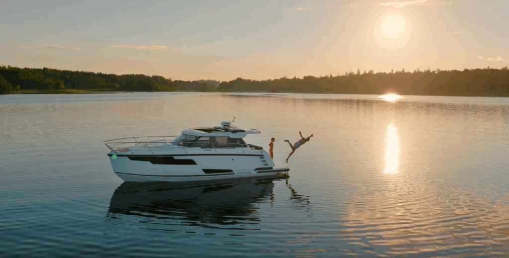 person leaps from back of Aquador boat - made by Nimbus Group - into calm water in the sunrise