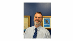 Man in tie smiles at camera