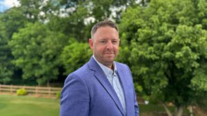 businessman in blue suit in front of trees