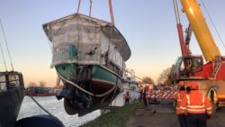 historic sailboat being lifted by crane