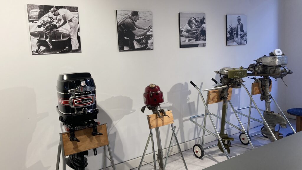A range of older outboard motors in a heritage display