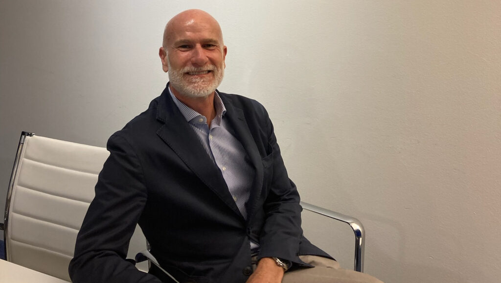 Marco Dona SAIM sits behind desk in an office