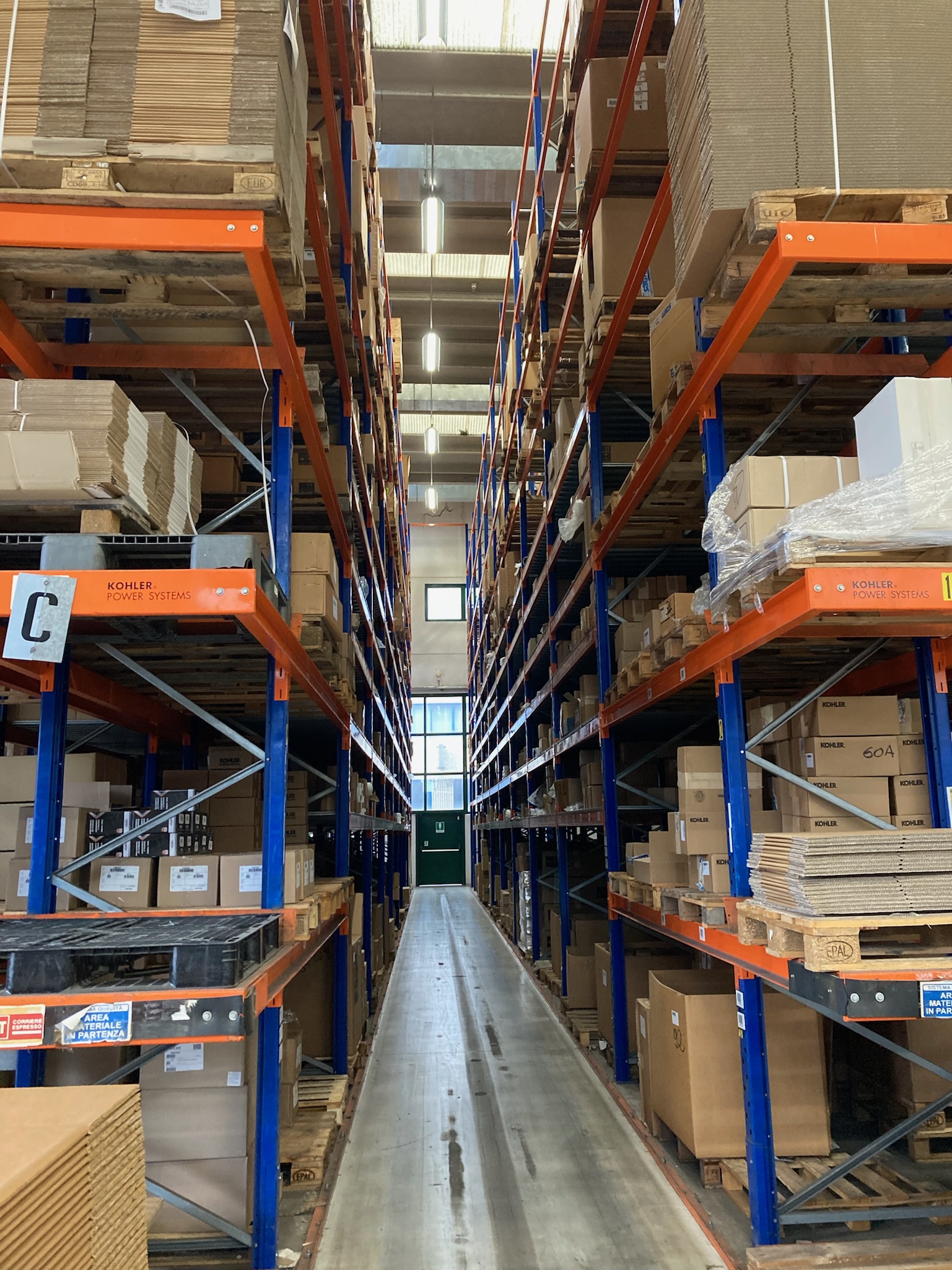Inside SAIM warehouse with orange and blue high stacks