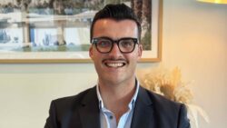 businessman sitting smiling with black rim glasses