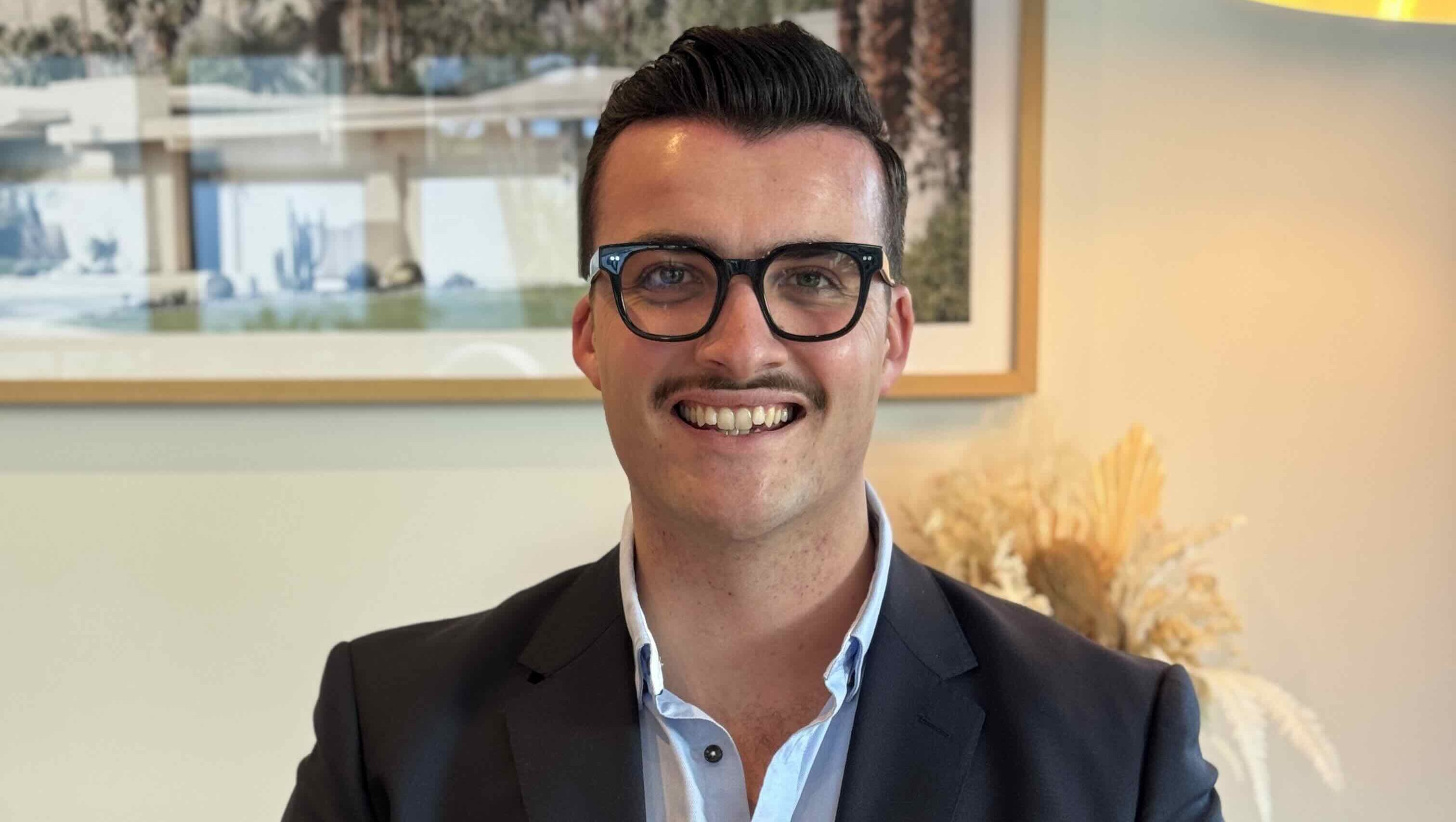 businessman sitting smiling with black rim glasses