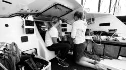 Black and white photo of two sailors in a cockpit