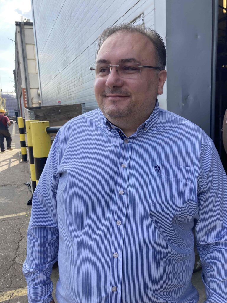 Il CEO del cantiere navale Conrad indossa una maglietta blu fuori dalla fabbrica