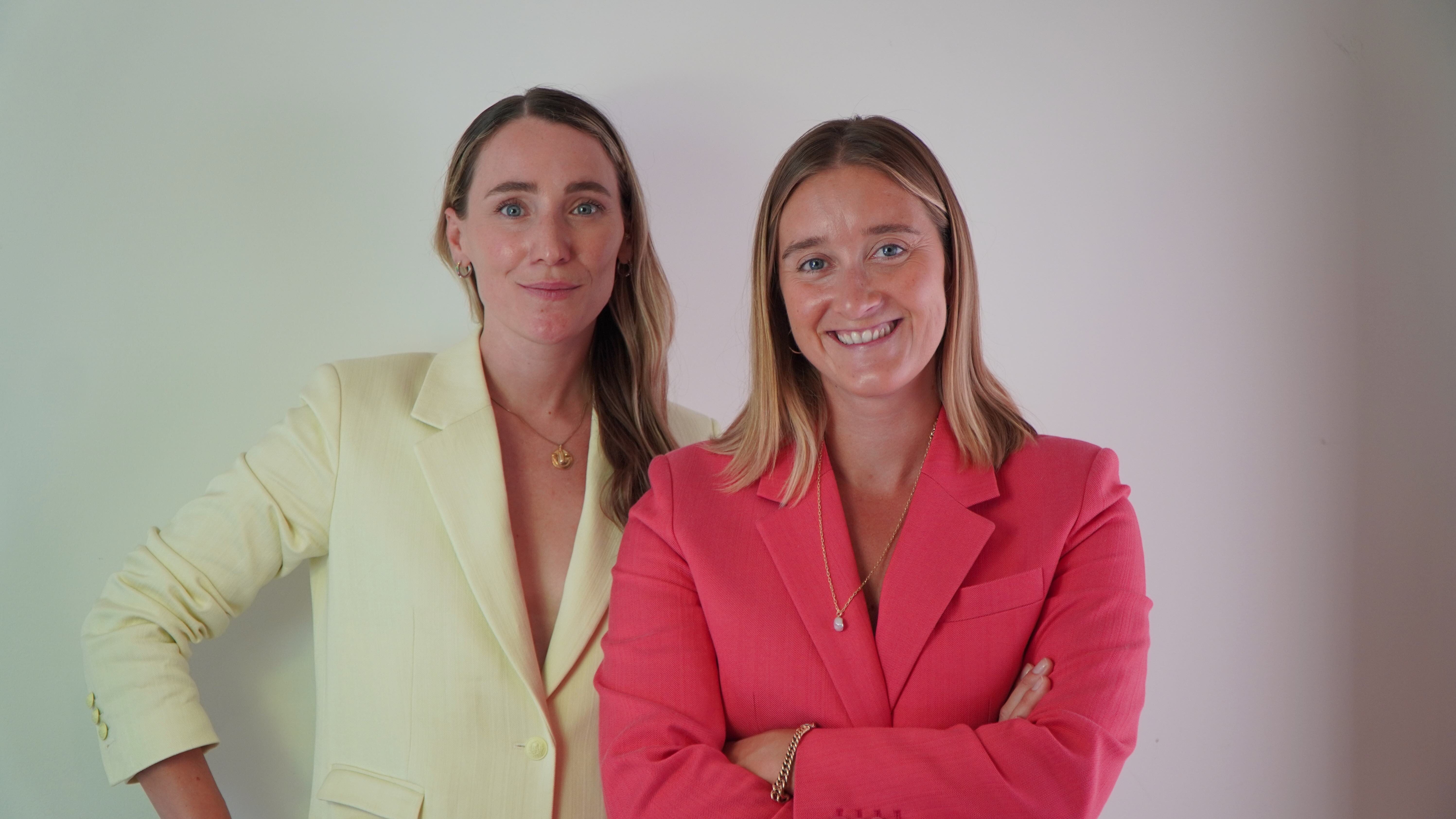 Two entrepreneurs smile at camera