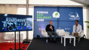 テレビ台の横にマイクを持ち「リムドライブ」と言っている2人の男性