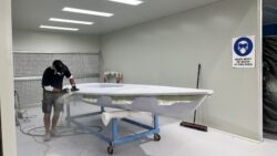 ILCA being made in Performance Marine Group premises Australia - worker in room with hull
