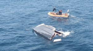Image of semi submerged boat wreckage and dinghy