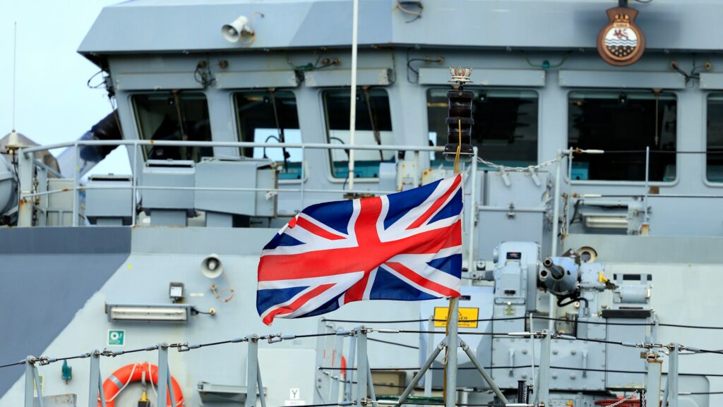 A Union Jack flag flies on a Navy ship