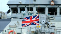 A Union Jack flag flies on a Navy ship