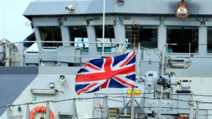A Union Jack flag flies on a Navy ship